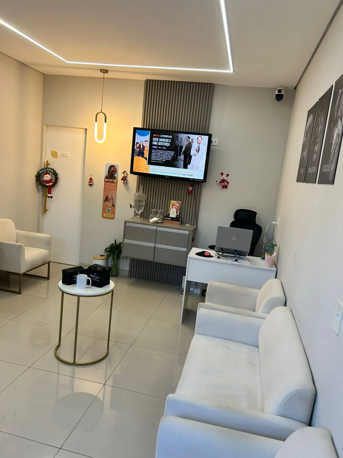 Sala de espera da Clínica Landim, com poltronas claras e televisão