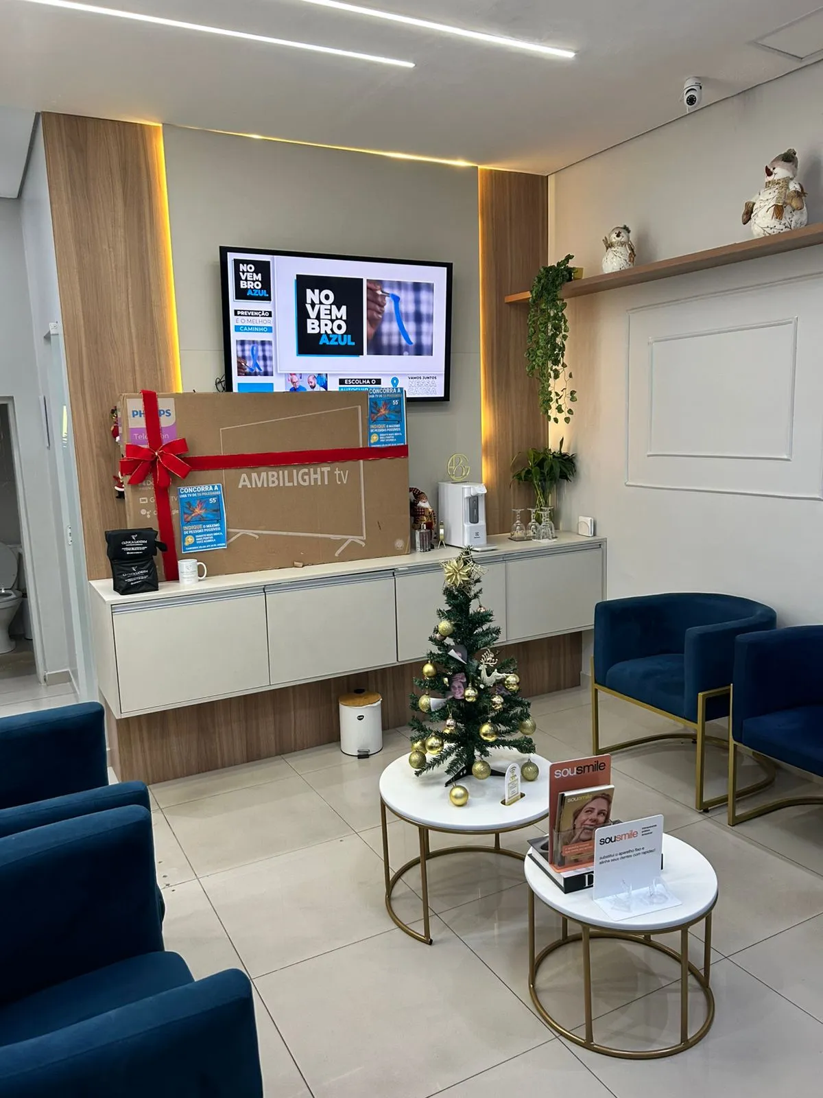 Balcão de recepção da clínica, com poltronas azuis para acompanhantes