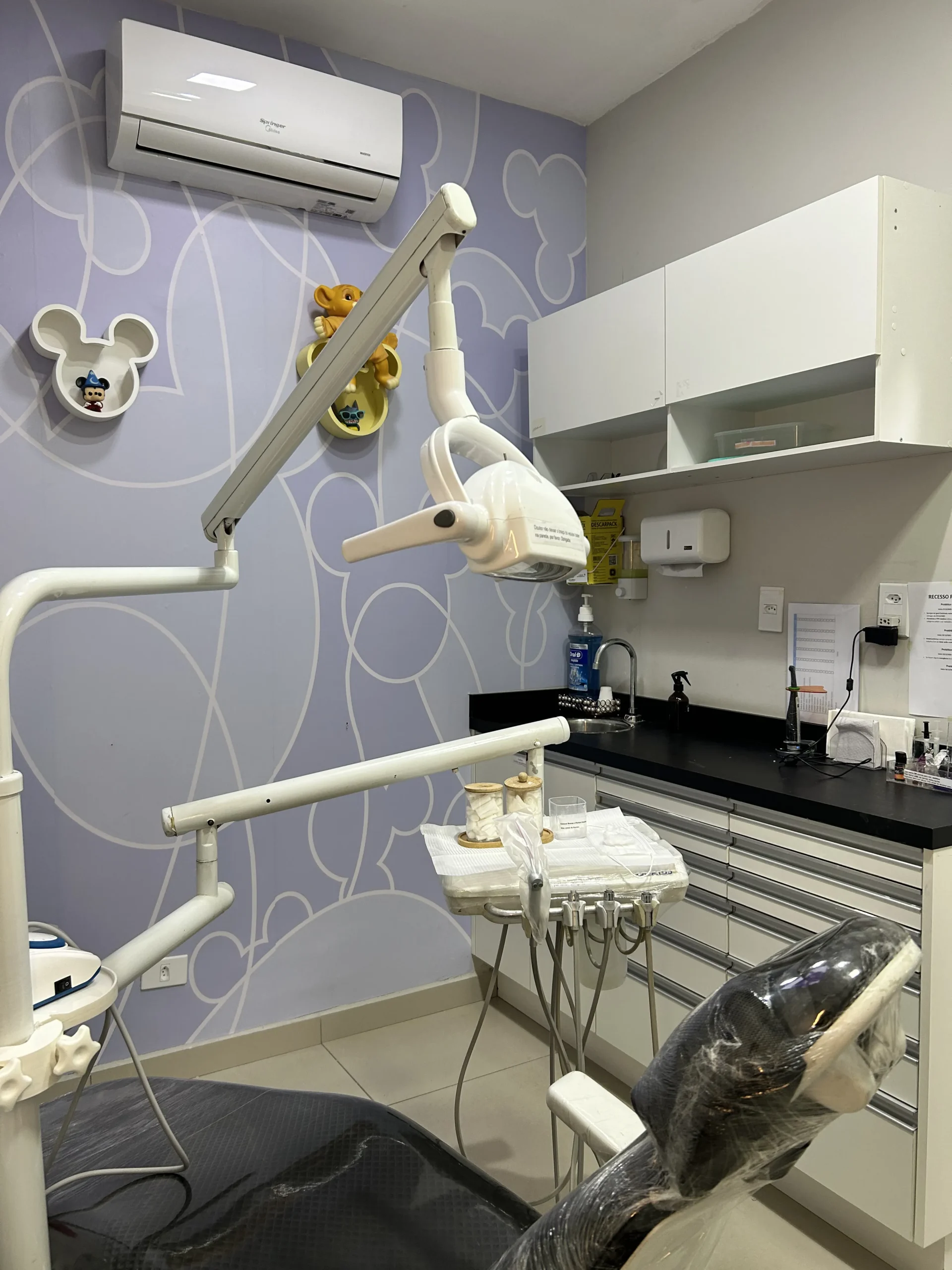 Consultório odontológico com refletor e bancada de instrumentos